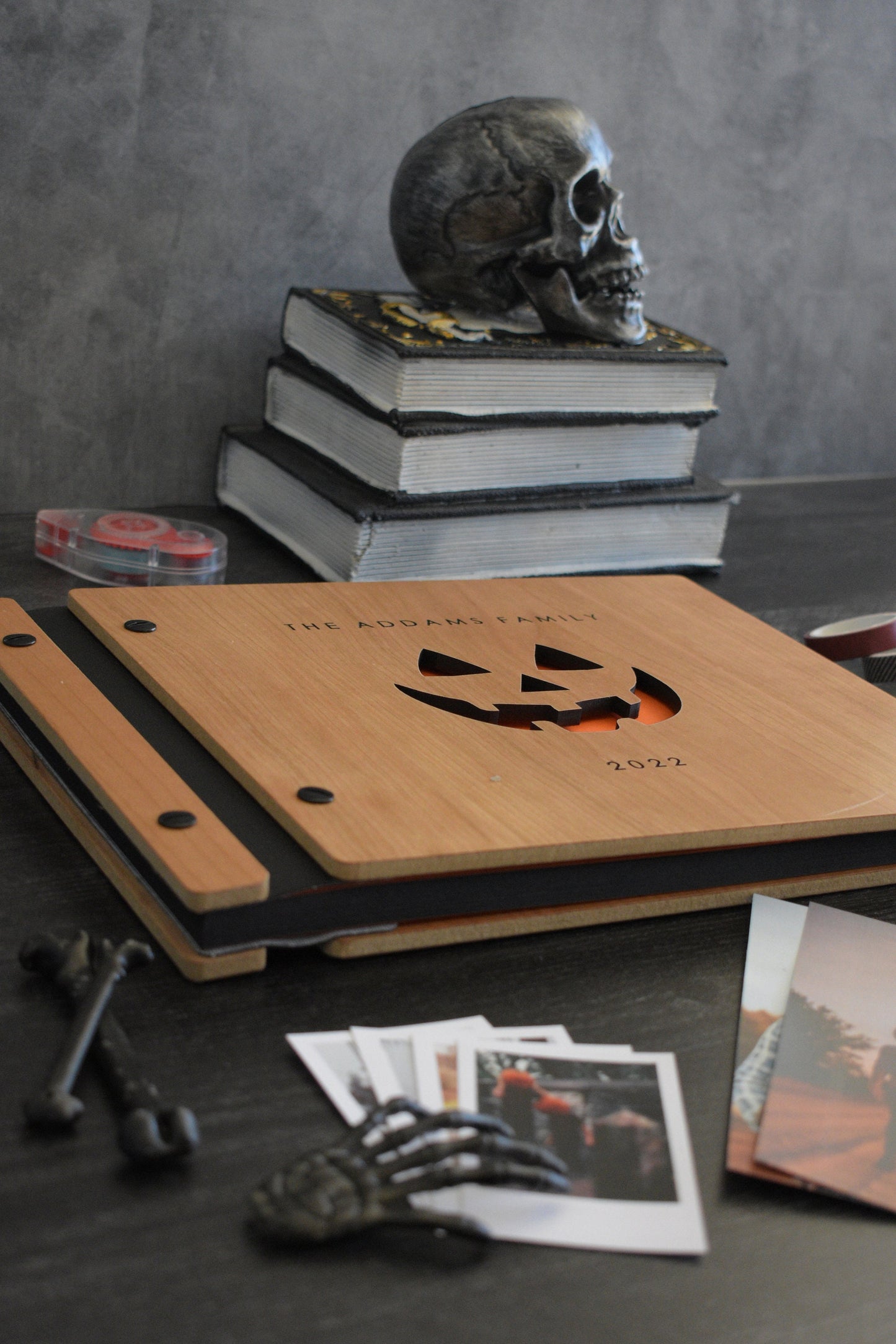 Engraved wooden Halloween book with cherry finish, black binding, black screws with your custom engraved family name and year, and pumpkin carved-out design. Perfect Halloween gift.