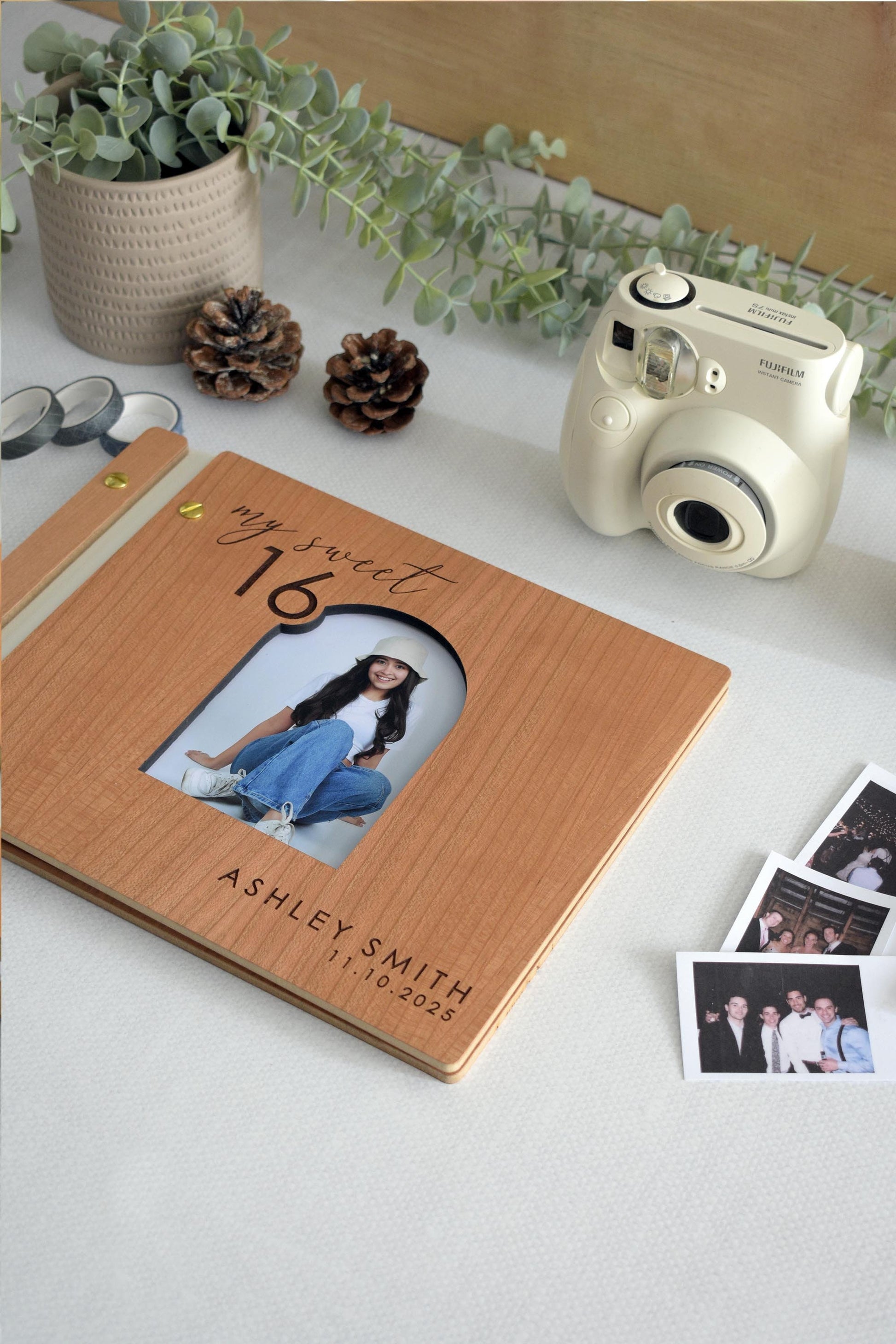 Custom wooden Sweet 16 guest book with a personalized photo and name engraving. Features a cherry wood cover, gold screws, and my sweet 16 design. Ideal for capturing special memories and messages. Surrounded by Polaroid photos and stationery.