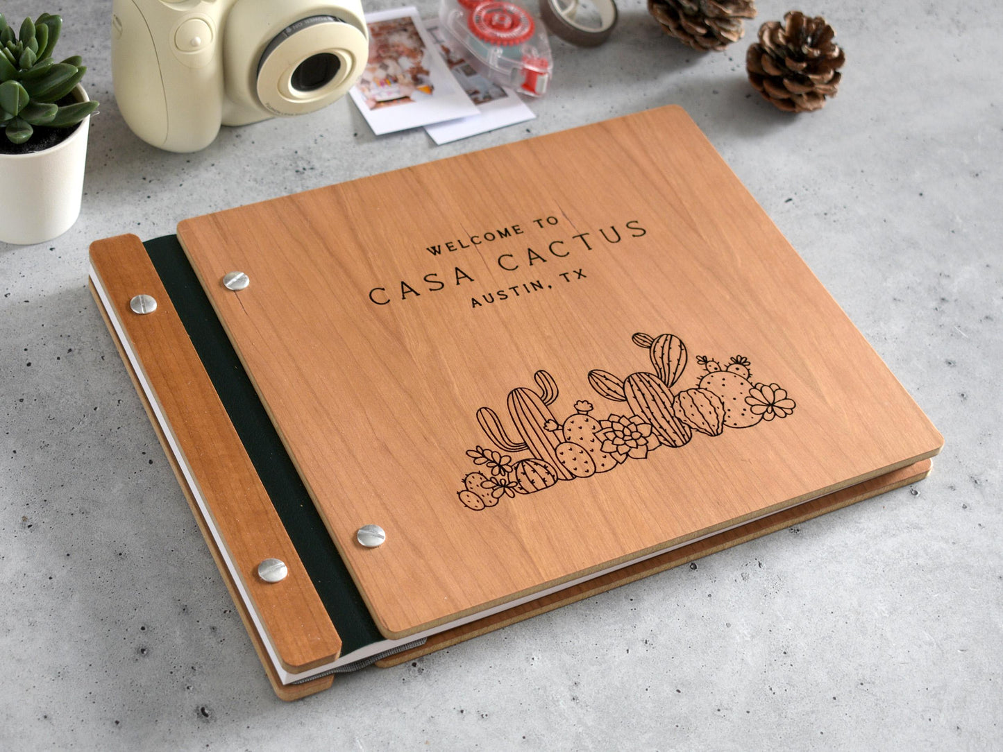 a wooden notebook sitting on top of a table next to a camera