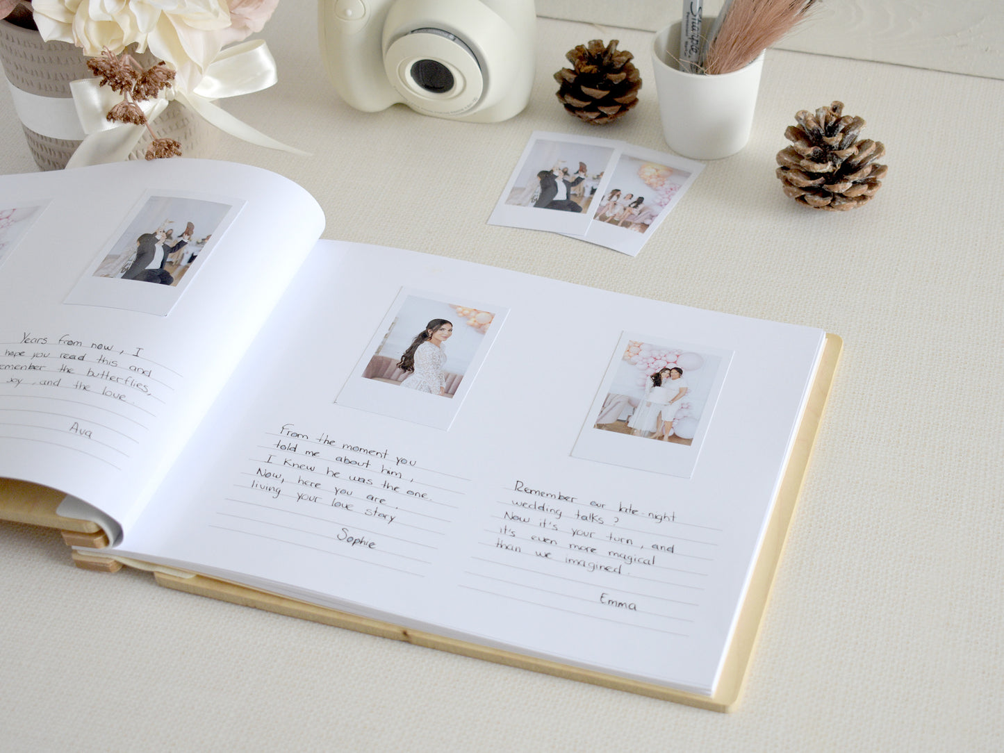 a photo album with handwritten notes, photographs, and a camera on a table.