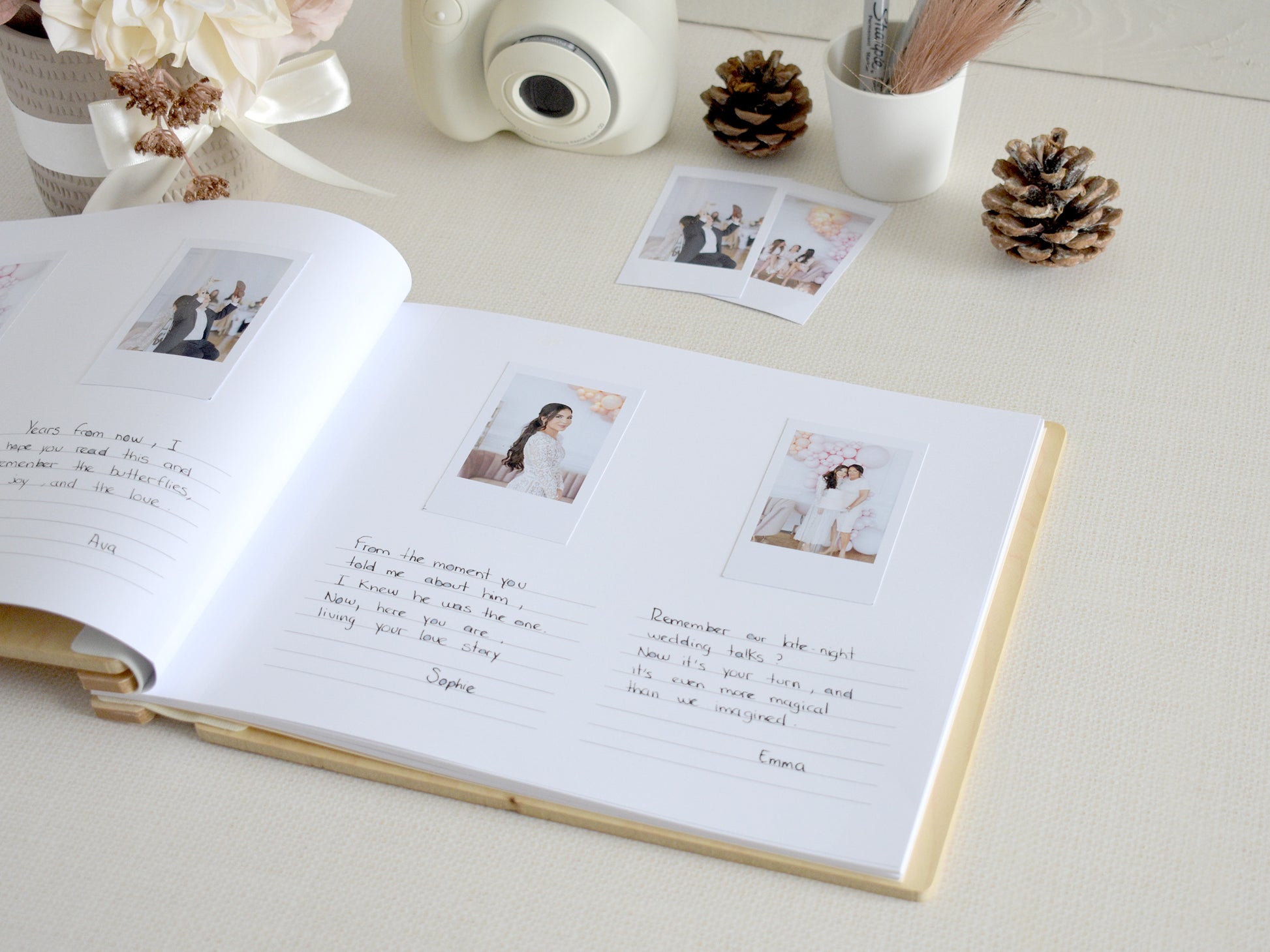 a photo album with handwritten notes, photographs, and a camera on a table.