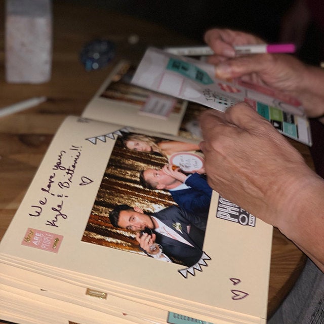 a person sitting at a table with a stack of magazines