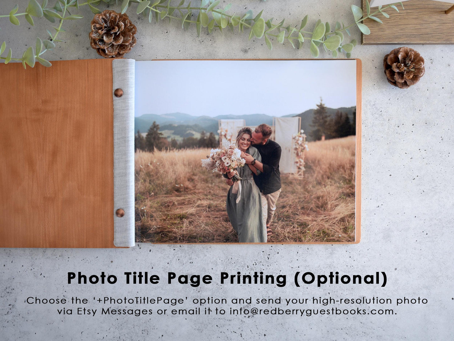 A couple embracing in a field with mountains in the background, surrounded by pine cones and greenery.