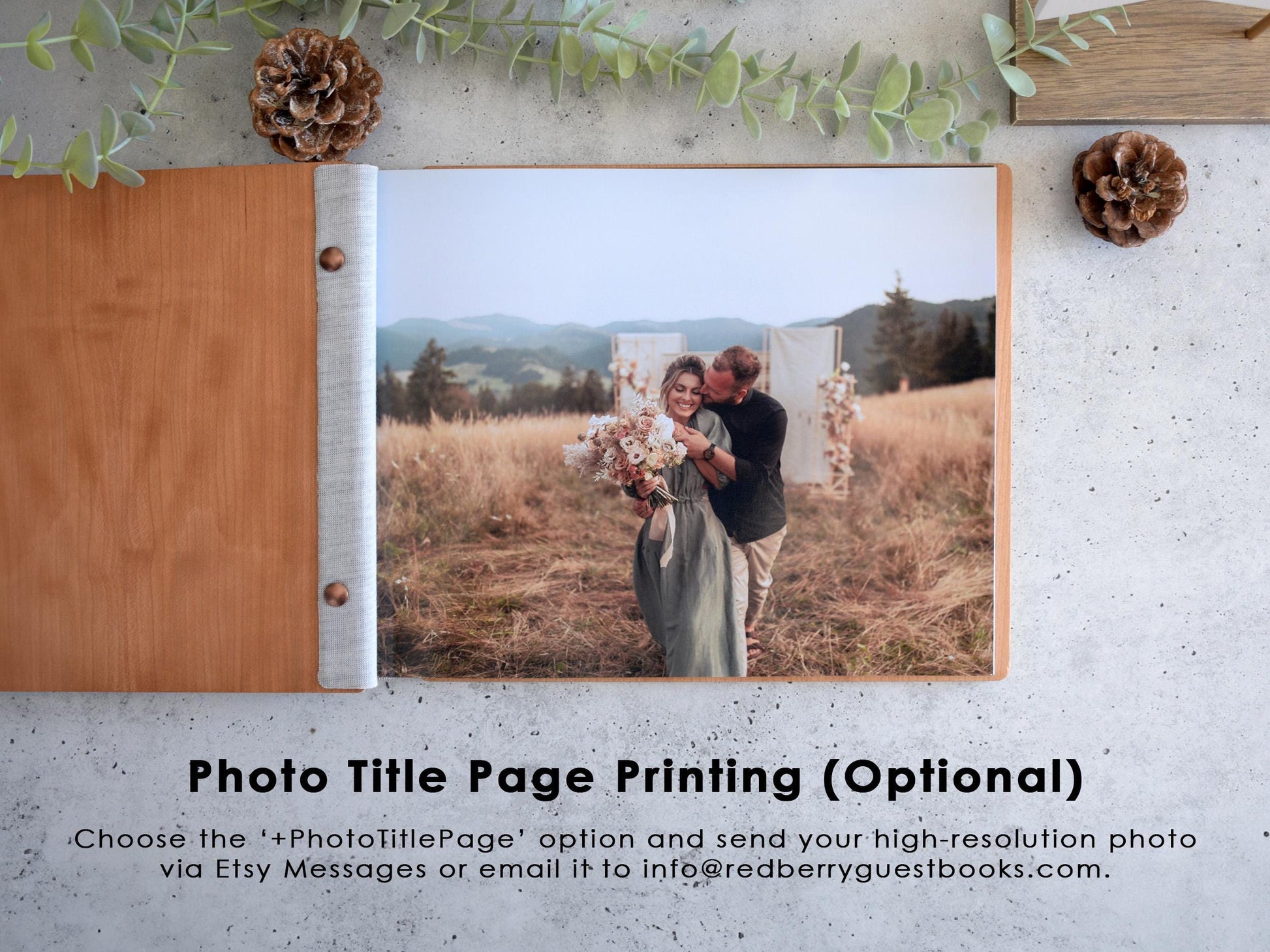 A couple embracing in a field with mountains in the background, surrounded by pine cones and greenery.