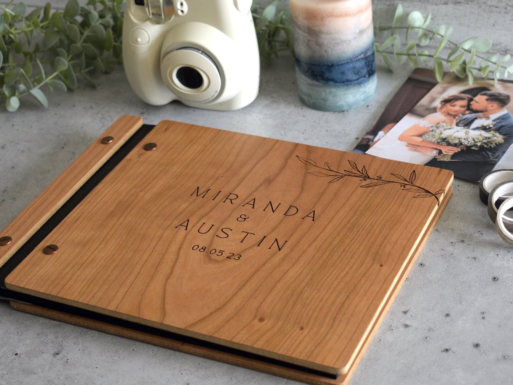 Engraved wooden wedding guest book in an amber finish with customized couples names and boho leaf design engraving.