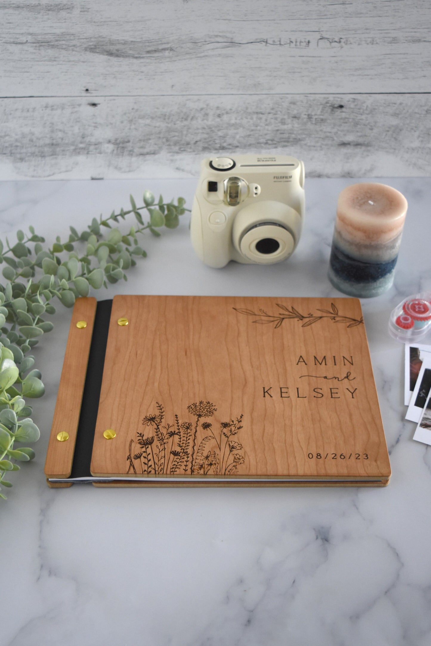 a wooden notebook sitting on top of a table next to a camera
