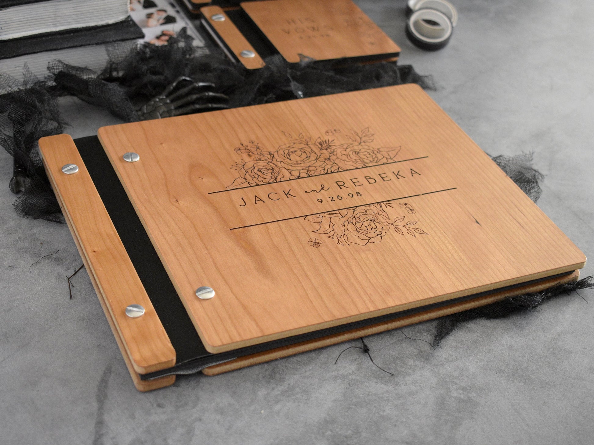 a wooden guest book with small vow books with gothic theme