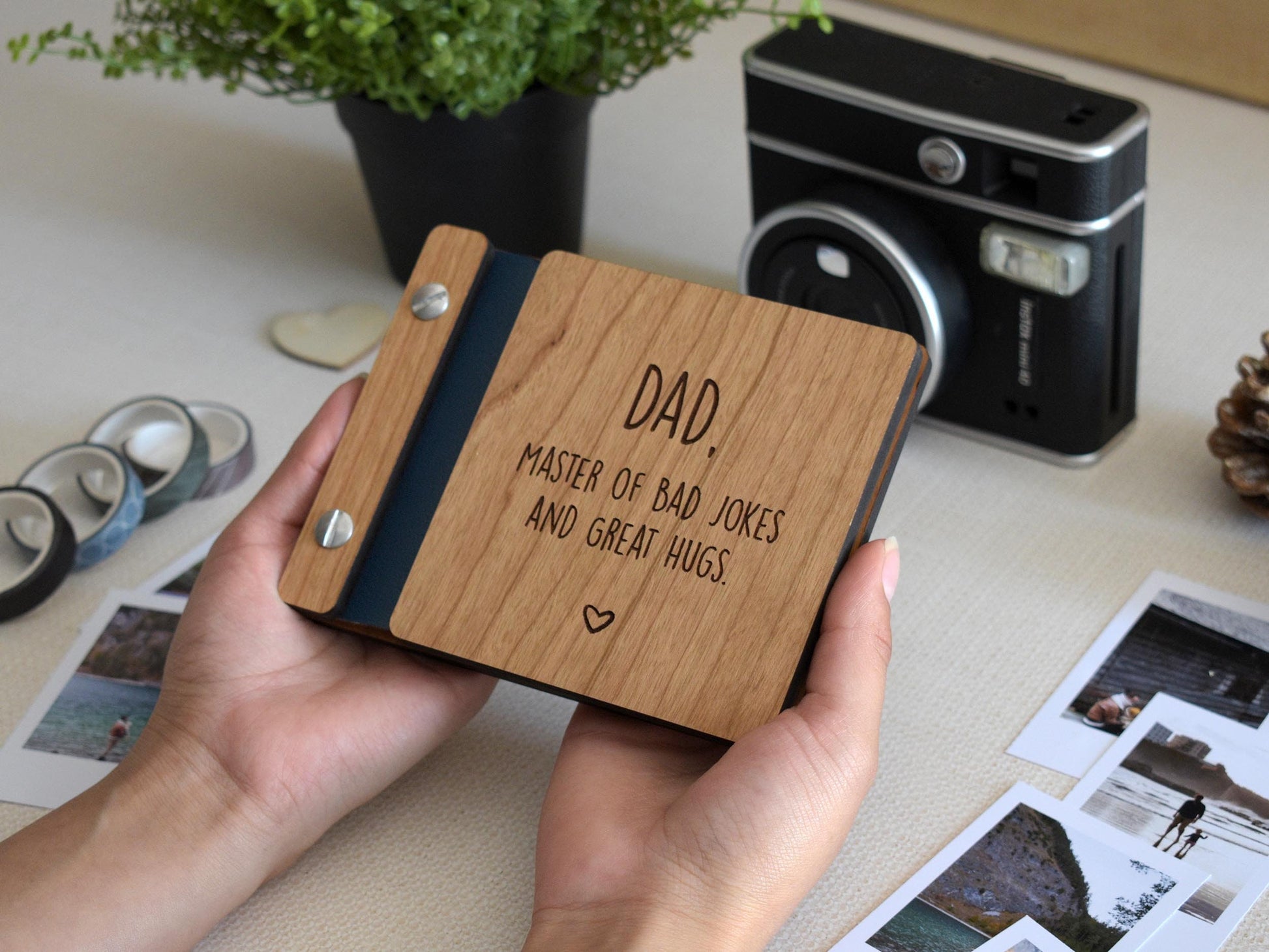 Handcrafted mini keepsake polaroid photo book with wooden cover and customizable engraving, perfect for Fathers Day. This unique gift for Dad features the message dad, master of jokes and great hugs and is an ideal Father&#39;s Day gift for him.