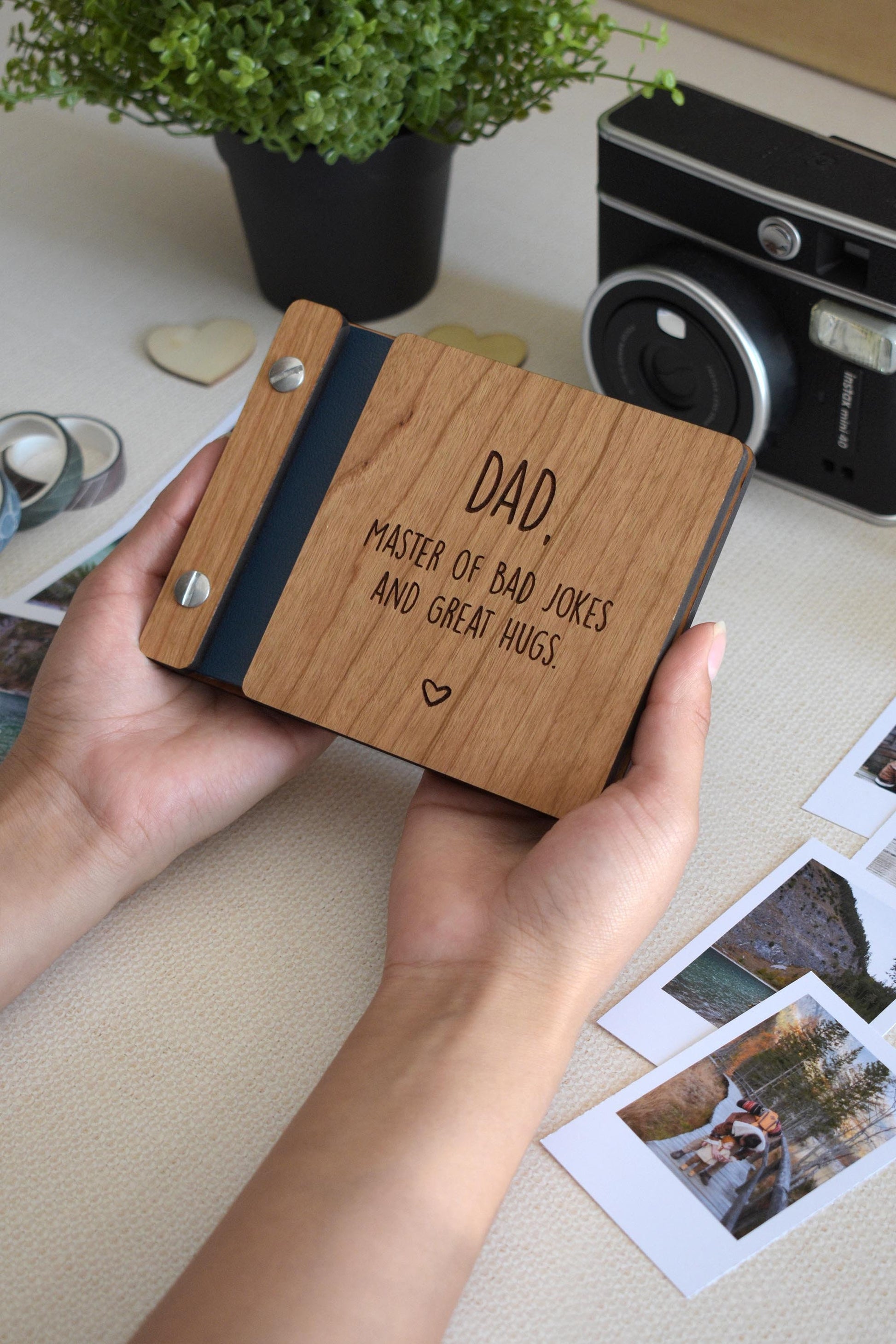 Handcrafted mini keepsake polaroid photo book with wooden cover and customizable engraving, perfect for Fathers Day. This unique gift for Dad features the message dad, master of jokes and great hugs and is an ideal Father&#39;s Day gift for him.