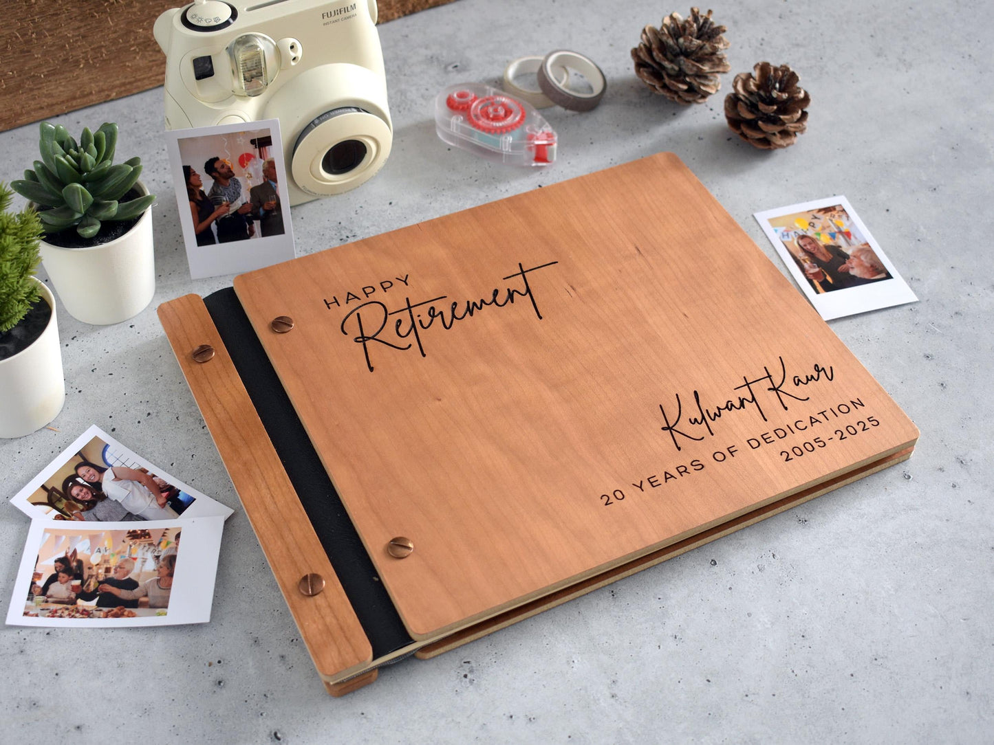 a wooden book with a couple&#39;s photos and a The retirement memory book is perfect for attaching photos and writing heartfelt messages; the perfect gift for women, men, and coworkers.polaroid camera