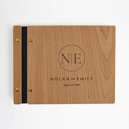 Wedding guest book made out of cherry wood, black vegan leather, gold hardware, and monogram design for the engraving.