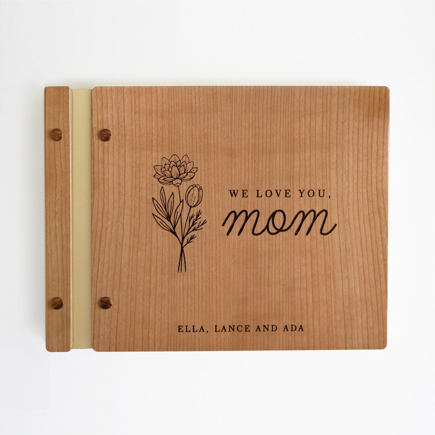 An 8.5x11" sized guest book stands on a table with a white background. The graduation guest book is made from cherry wood, ivory binding, and copper hardware. This is the perfect gift for Mom this Mother's Day!